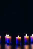 Free photo burning candle on black background with backlight memorial day