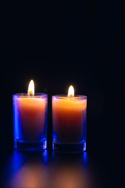 Free Photo burning candle on black background with backlight memorial day