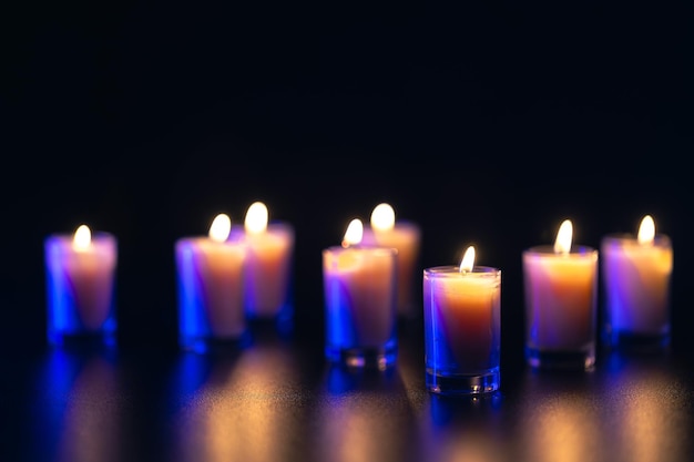 Free photo burning candle on black background with backlight memorial day