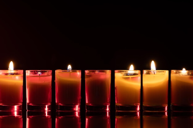 Free Photo burning candle on black background with backlight memorial day