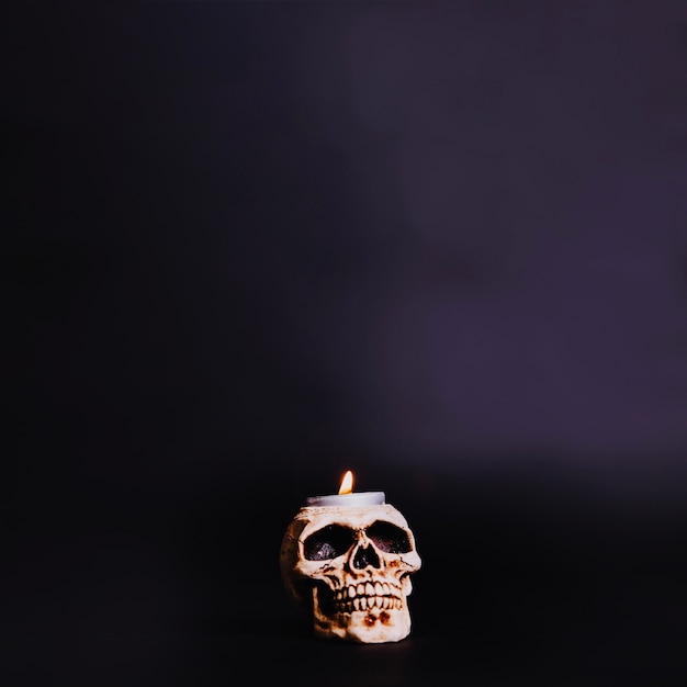 Burning candle in skull