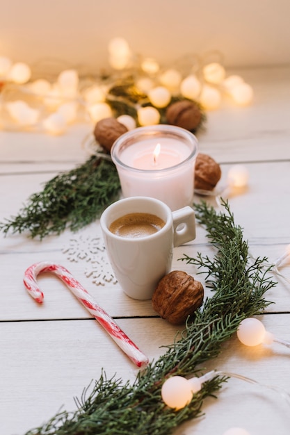 Free photo burning candle with cup and walnuts