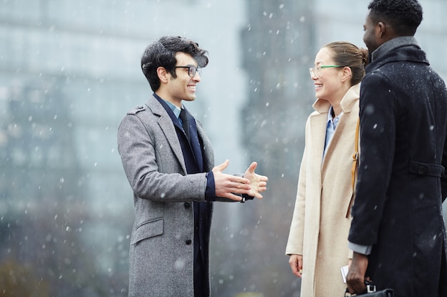 Free photo business colleagues chatting in snowy street