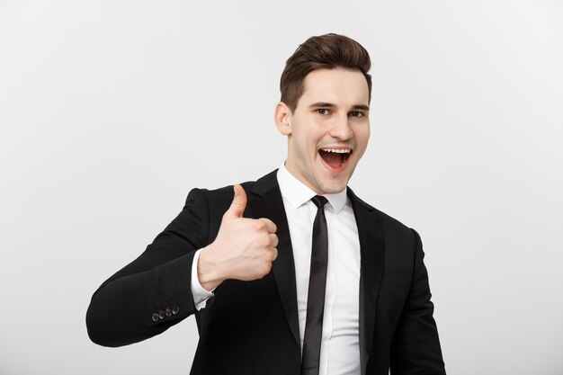 Business concept portrait of excited man with opened mouth dressed in formal wear giving thumbsup ag...