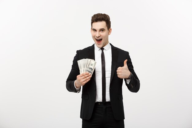 Business Concept - Successful Businessman holding dollar bills and showing thumb up isolated over white background.