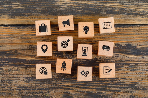 Free Photo business concept with icons on wooden cubes on wooden table flat lay.