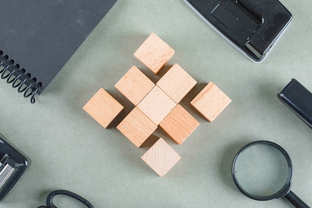 Free Photo business concept with wooden blocks, black notebook, magnifying glass top view.