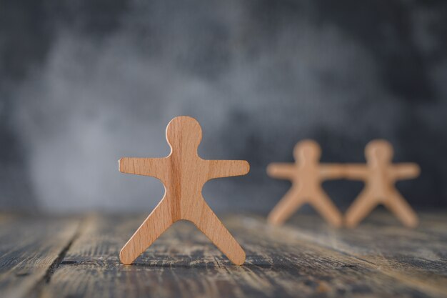 Business concept with wooden figures of people side view.