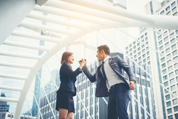 Business couple hands up doing yes outdoor. Concept of teamwork