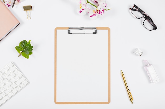 Business desk arrangement with empty clipboard