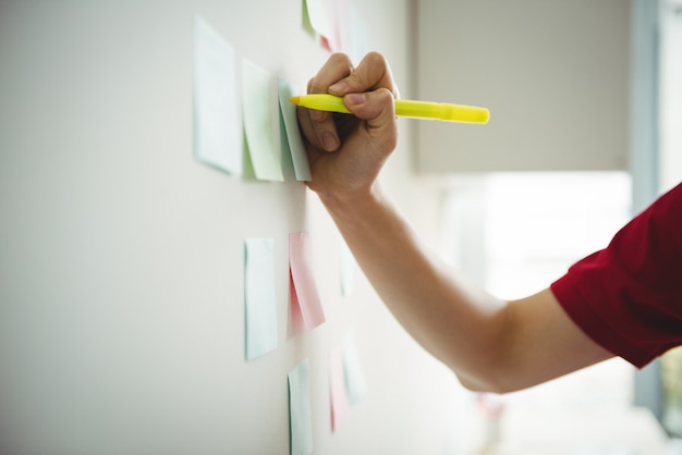 Business executive writing on sticky notes