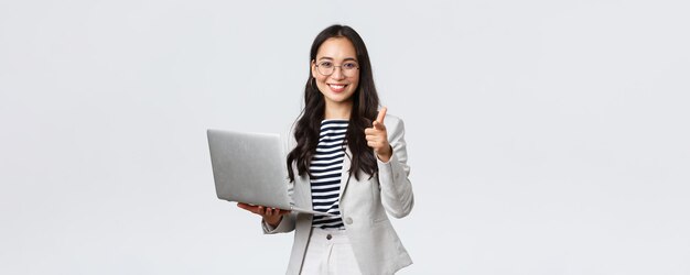 Business finance and employment female successful entrepreneurs concept Smiling pleased businesswoman praise coworker who made good point pointing finger camera satisfied hold laptop