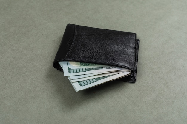 Free photo business and financial concept with dollars in wallet on grey surface flat lay.