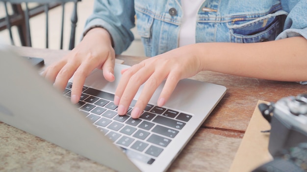 Business freelance Asian woman working, doing projects and sending email on laptop or computer while sitting on table in cafe. Lifestyle smart beautiful women working at coffee shop concepts.