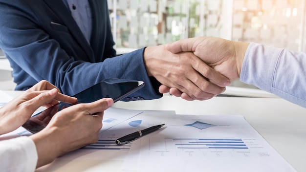 Business handshake of two men demonstrating their agreement to sign agreement or contract between their firms, companies, enterprises