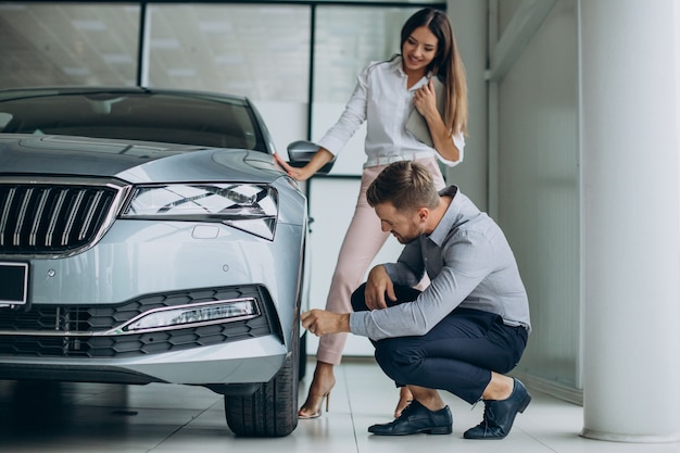 Business man choosing a car with a sales woman at car salon