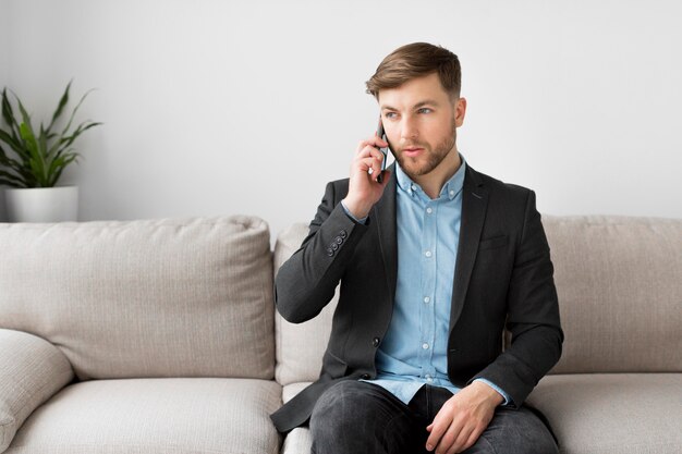 Business man on couch talking over phone