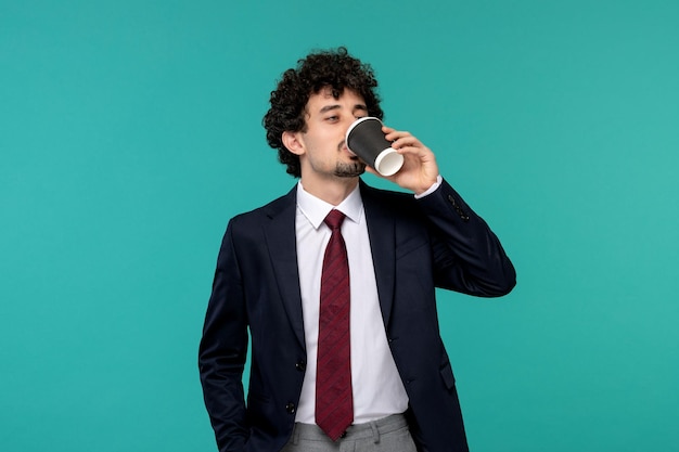 Business man curly cute handsome guy in black suit drinking coffee