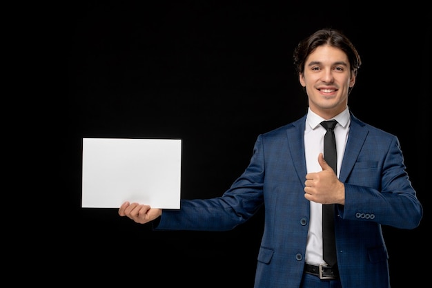 Business man cute lovely guy in dark blue suit with the tie smiling with the paper