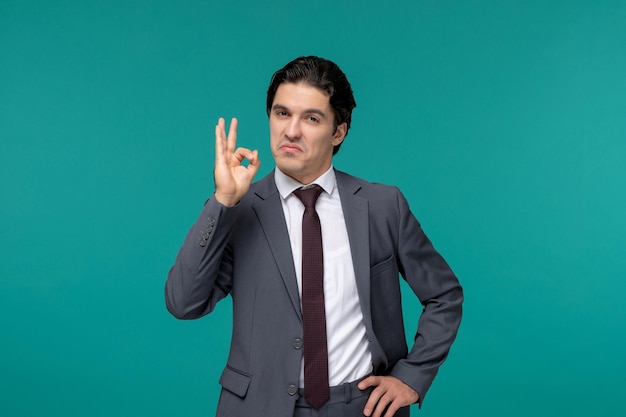 Business man handsome young brunette guy in grey office suit and tie showing ok sign