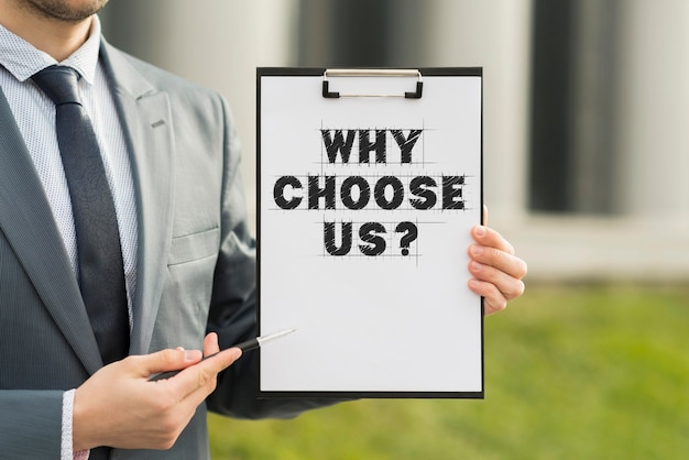 Free Photo business man holding a clipboard with the why choose us question