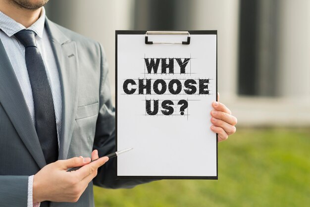 Business man holding a clipboard with the why choose us question