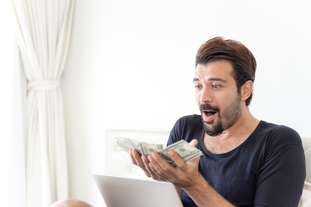 Free photo business man  holding money us dollar bills  in home office