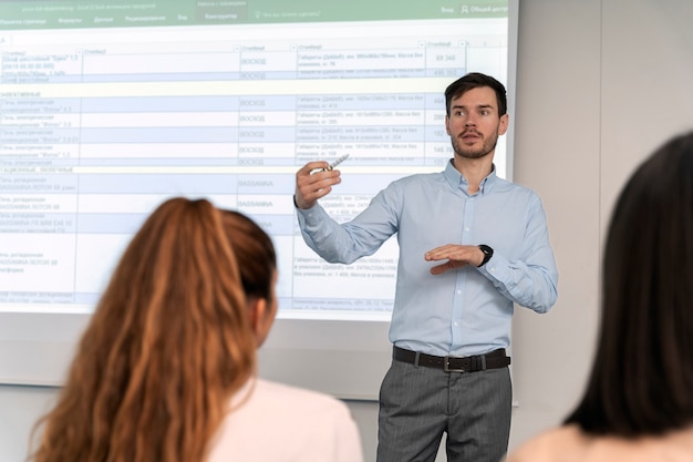 Free photo business man holding a presentation in the office for her colleagues