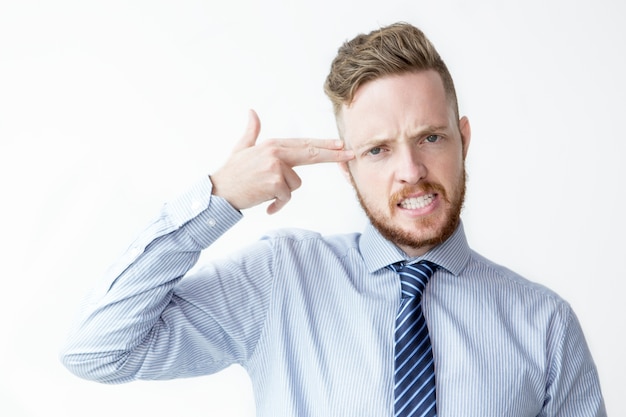 Free photo business man shooting himself with fingers