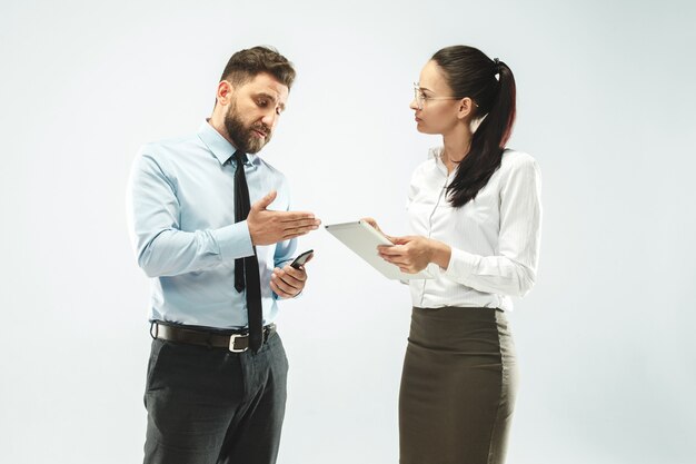 A business man shows the laptop to his colleague in the office.