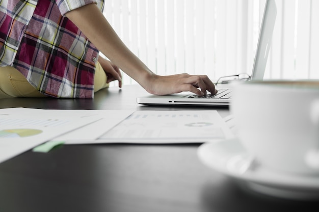 Free Photo business man sitting at table and typing on laptop