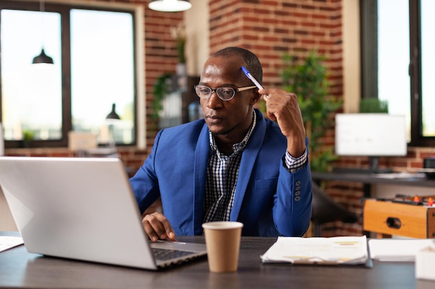 Business man thinking about innovative solution and planning project on laptop. Pensive entrepreneur brainstorming financial ideas to plan marketing strategy on computer for startup.