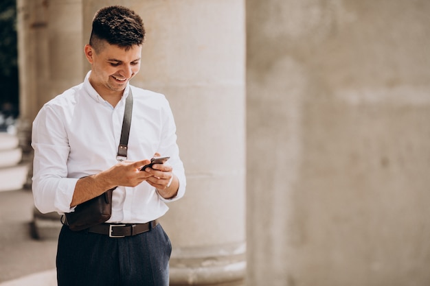 Free photo business man using phone by the university