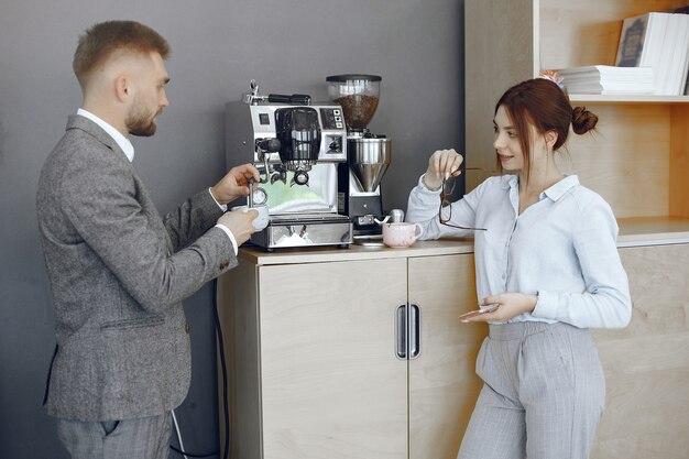 Business man and woman at the office. Coffee break in the hallway of the big corporation.