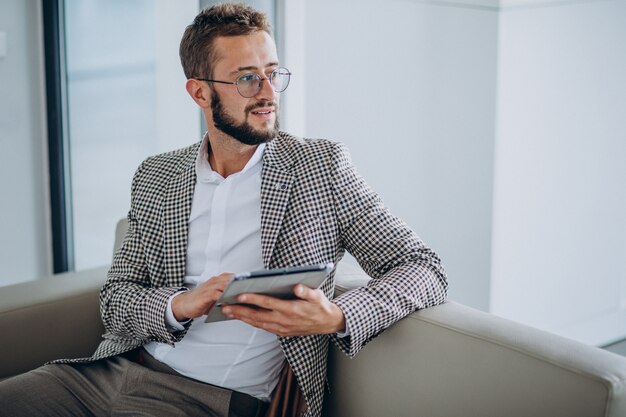 Business man working on tablet and sitting on sofa