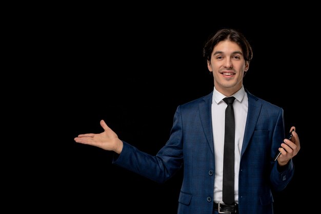 Business man young smiling handsome guy in dark blue suit with the tie holding phone