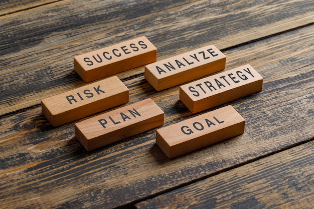 Business and marketing concept with wooden blocks on wooden table high angle view.