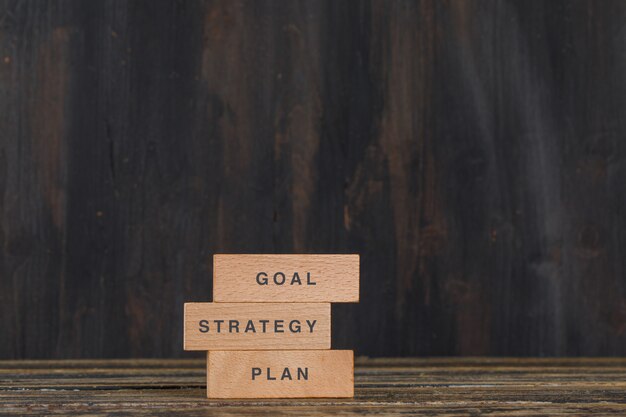 Business and marketing concept with wooden blocks on wooden table side view.