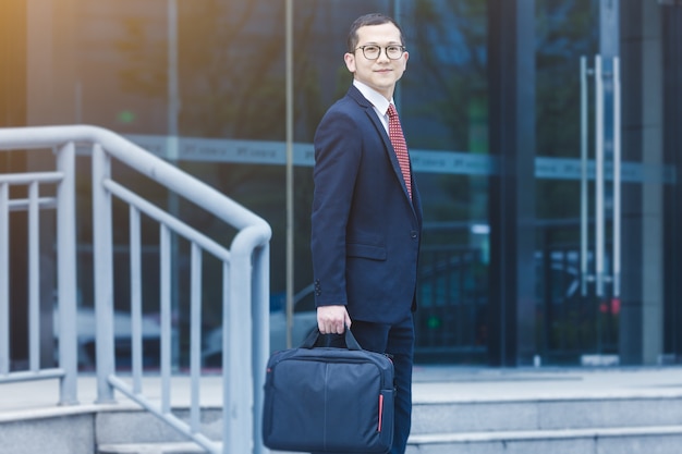 Free photo business men carry laptops to the office building