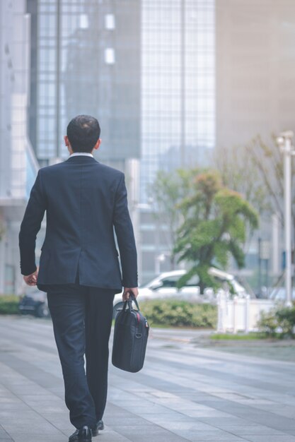 Business men carry laptops in the parking lot