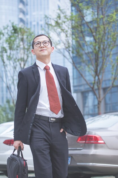 Business men carry laptops in the parking lot