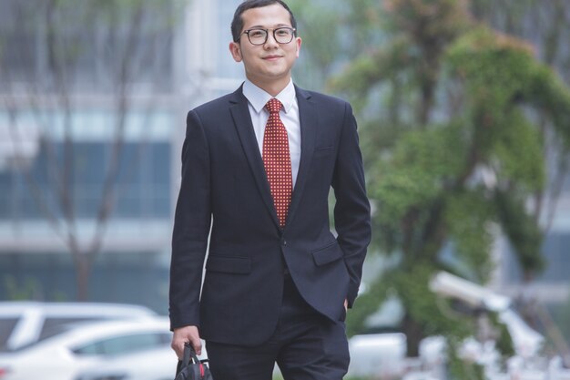 Business men carry laptops in the parking lot