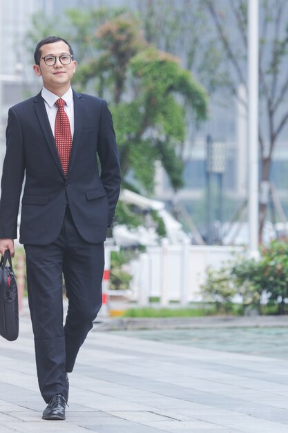 Business men carry laptops in the parking lot