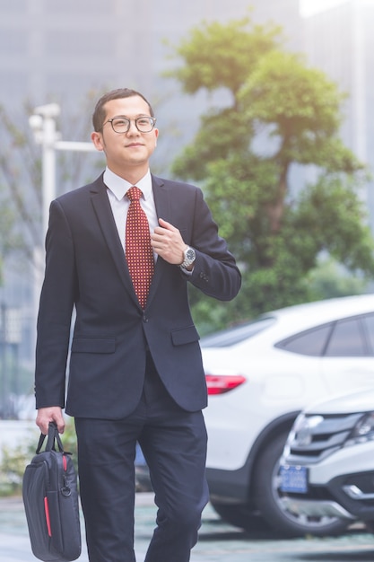 Business men carry laptops in the parking lot