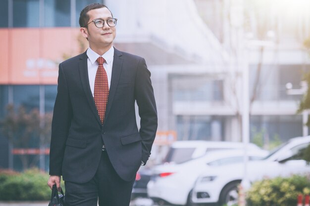 Business men carry laptops in the parking lot