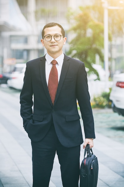 Business men carry laptops in the parking lot