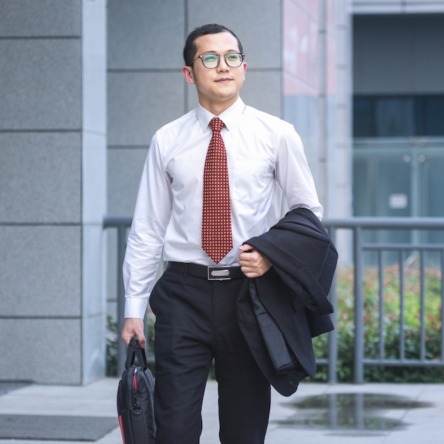 Business men carry laptops to work at the entrance of an office building