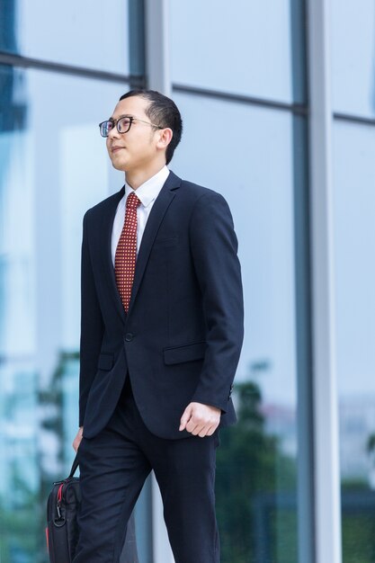 Business men carry laptops to work at the entrance of an office building