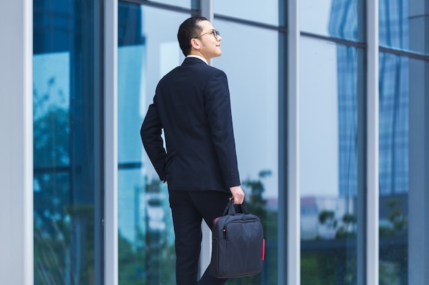 Free Photo business men carry laptops to work at the entrance of an office building