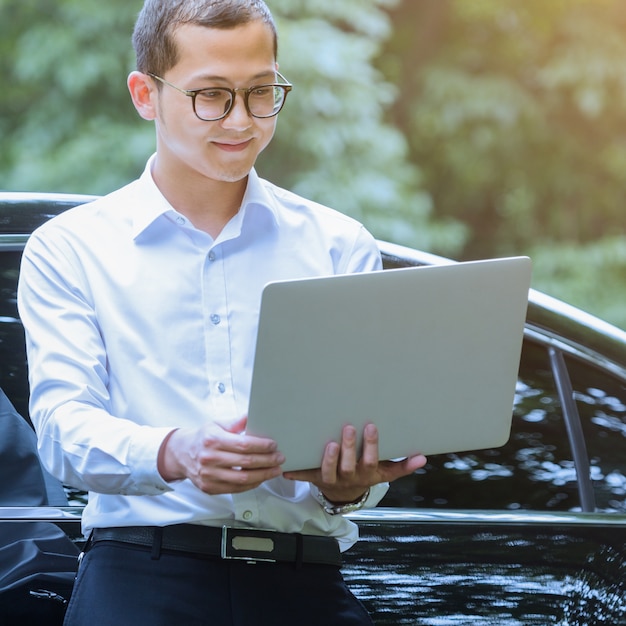 Free Photo business men use laptops alongside outdoor vehicles